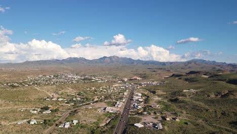 4K-Drone-flyover-highway-in-Kingman-Arizona,-light-traffic-with-mountains-in-the-background,-large-clouds-behind-the-Hualapai-mountains