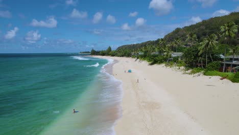 Bird's-eye-view-over-people-on-vacation-enjoying-sunny-day-on-tropical-beach-of-North-Shore-Oahu,-Hawaii-island
