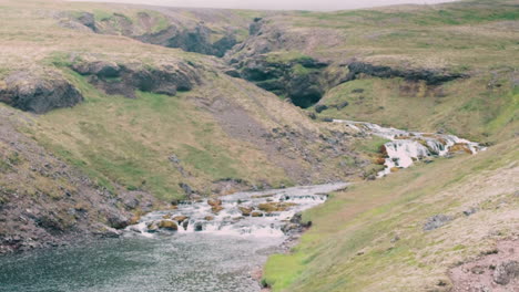 Ein-Ruhiger-Fluss-Mit-Wasserfall,-Aufgenommen-In-Island