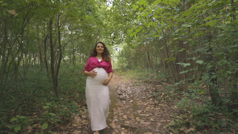 Schwangere-Mutter,-Die-Beim-Training-Den-Waldweg-Hinuntergeht-Und-Dabei-Sorgfältig-Zweige-Vermeidet