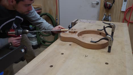 Craftsman-Paying-Attention-To-Detail-When-Drilling-Hole-Into-Musical-Instrument