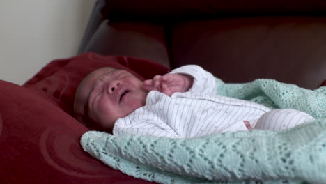 New-Born-Baby-Boy-Crying-And-Fidgeting-Laying-Down-On-Pillow-On-Sofa