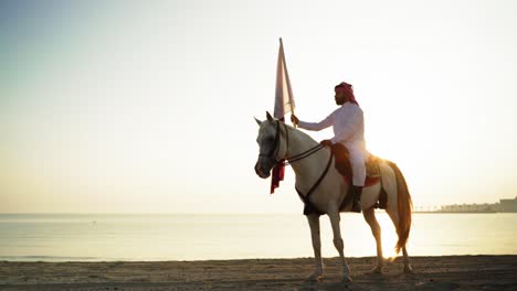 Ein-Ritter-Zu-Pferd,-Der-Die-Katar-flagge-Nahe-Dem-Meer-Hält-7