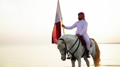 Un-Caballero-A-Caballo-Sosteniendo-La-Bandera-Qatar-En-Cámara-Lenta