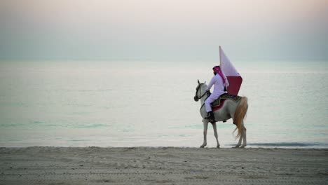 A-knight-riding-a-horse-walking-and-holding-Qatar-flag-near-the-sea-1