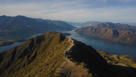 Eine-Push-forward-drohne-Schoss-über-Den-Gipfel-Des-Roys-Peak-In-Neuseeland-In-Richtung-Lake-Wanaka