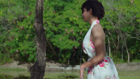 Hispanisches-Mädchen-Geht-Auf-Einen-Baumstumpf-Im-Park-Mit-Einem-See-Im-Hintergrund-Zu