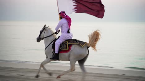 A-knight-riding-a-horse-running-and-holding-Qatar-flag-near-the-sea-3