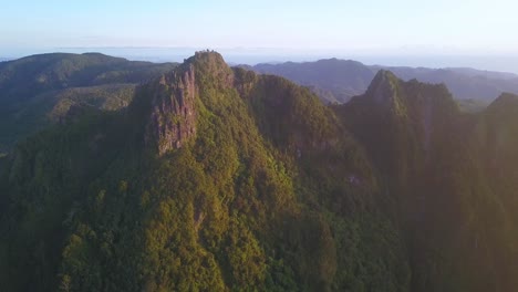 Flying-alongside-jagged-pinnacles-in-the-Coromandel-mountain-ranges-on-a-sunny-morning,-New-Zealand