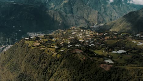 Vista-Aérea-De-Drones-De-Baños-De-Agua-Bendita-Con-Volcán-Tungurahua-En-Las-Montañas-Andinas-De-Ecuador