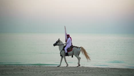 A-knight-riding-a-horse-walking-and-holding-Qatar-flag-near-the-sea