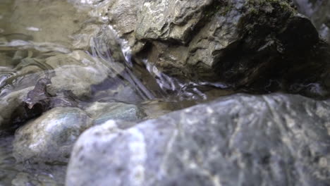 Close-up-of-a-small-stream-in-the-swiss-alps-flowing-between-stones
