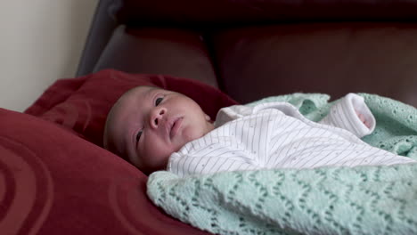 Awake-New-Born-Baby-Boy-Laying-Down-On-Pillow-On-Sofa