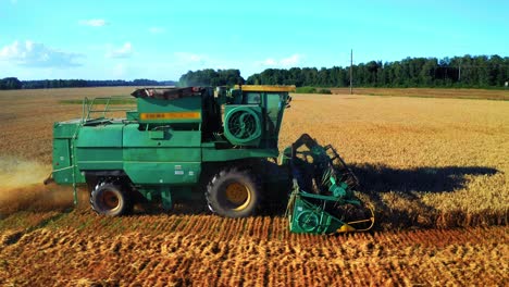 Side-View-Of-Mechanical-Grain-Reaping-Machine-Cutting-Mature-Crops-On-Farmland