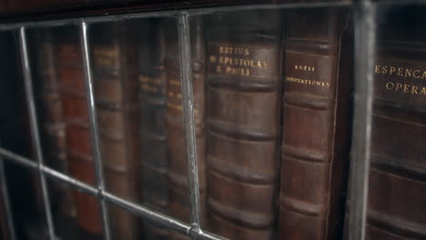 Antiguos-Libros-Encuadernados-En-Cuero-En-Un-Gabinete-Medieval-De-Vidrio-Con-Plomo-De-La-Edad-Media-En-Una-Biblioteca