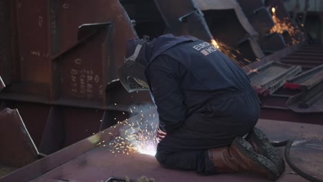 Metal-construction-worker-is-welding-the-floor-on-a-shipyard-repair