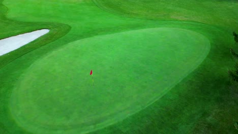 Drone-orbiting-and-spinning-around-flag-on-golf-green
