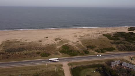 White-bus-driving-along-coastal-ocean-road-of-Maldonado-area-in-Uruguay