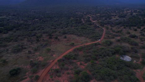 Car-Driving-Along-South-African-Farm-Track-In-Bush-Landscape,-Aerial