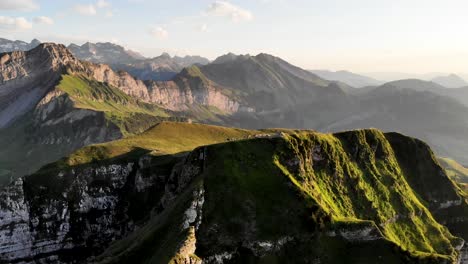 Luftüberführung-über-Den-Niederbauen-Chulm-Gipfel-In-Uri,-Schweiz-Mit-Blick-Auf-Grasende-Kühe-Auf-Dem-Glühenden-Alpengras-An-Einem-Sommerabend-In-Den-Schweizer-Alpen