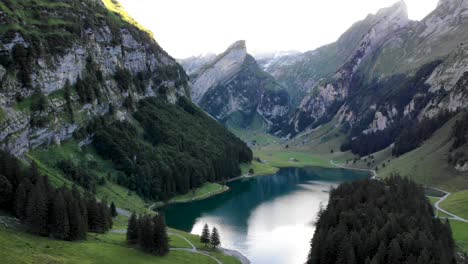 Sobrevuelo-Aéreo-A-Lo-Largo-De-Las-Orillas-Del-Lago-Seealpsee-En-Appenzell,-Suiza,-Con-Un-Reflejo-De-Los-Picos-Alpstein-En-El-Agua-Del-Lago