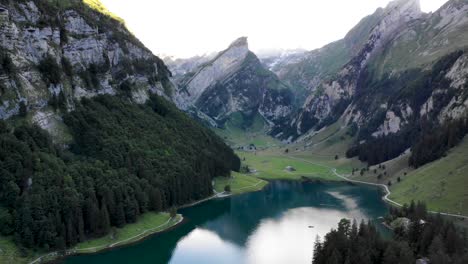 Sobrevuelo-Aéreo-Hacia-El-Agua-Del-Lago-Seealpsee-En-Appenzell,-Suiza-Con-Un-Reflejo-De-Los-Picos-Alpstein-En-El-Lago