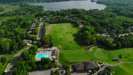 Orbiting-drone-shot-of-a-driving-range-at-a-country-club-with-a-pro-shop-and-swimming-pool