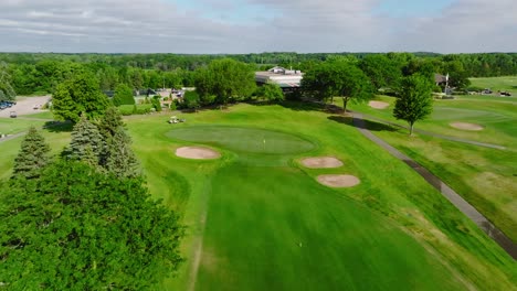 Push-in-drone-shot-of-a-golf-green-with-green-side-bunkers-at-a-golf-club