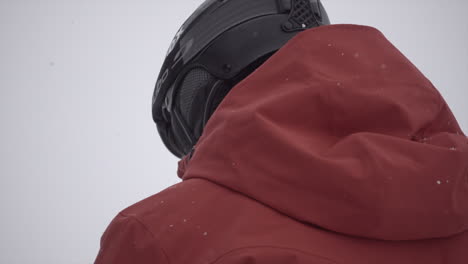 Red-jacket-and-black-helmet-of-a-skier-in-the-Swiss-alps-during-a-snowy-day