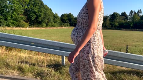 Close-up-shot-of-pretty-pregnant-woman-with-brown-skin-and-belly-walking-outdoors-during-sunny-day-in-wilderness---slow-motion-footage,4k