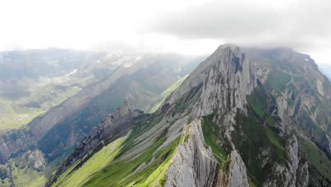 Aerial-flyover-over-the-cliffs-of-Schafler-ridge-in-Appenzell,-Switzerland-with-on-a-cloudy-afternoon