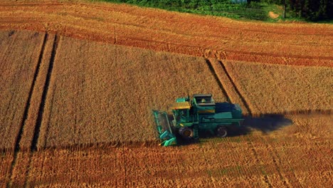 Green-Combine-Harvester-On-A-Wheat-Field-In-Lithuania---aerial-shot