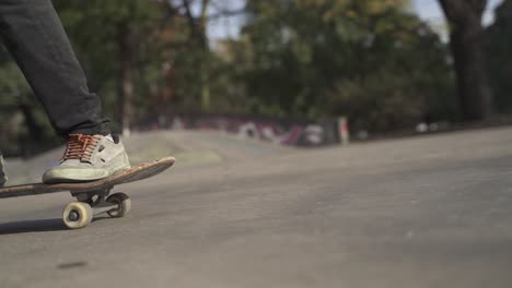 Low-angle-slow-motion-shot-of-skateboarder-jumping-and-hitting-the-ground-with-board-outdoors-at-skatepark