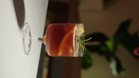 Vertikale-Videohand,-Die-Zu-Hause-Ein-Espresso-Tonikum-Mit-Rosmarinzweig-In-Einem-Schönen-Trinkglas-Dekoriert