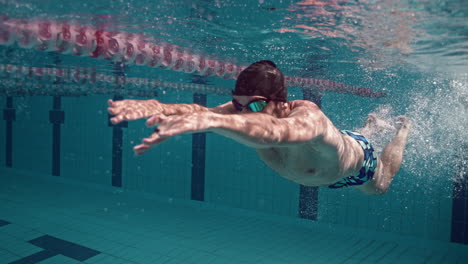 Professioneller-Schwimmer-In-Zeitlupe-Unter-Wasser,-Der-Die-Wand-Drückt-Und-Freistil-Schwimmt,-4k