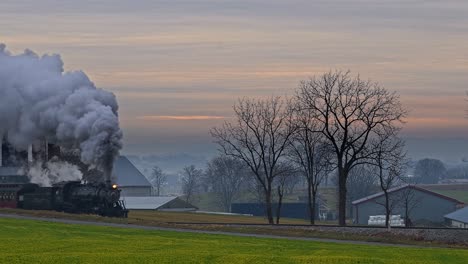 A-View-of-an-Antique-Restored-Steam-Passenger-Train-Approaching-in-the-Early-Morning-Blowing-Steam-on-a-Winter-Day