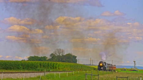 A-View-of-a-Restored-Antique-Steam-Passenger-Train-Approaching-Blowing-Black-Smoke-and-Steam-on-a-Sunny-Day