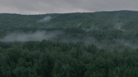 Drone-flying-through-a-beautiful-foggy-mountain-top-landscape,-pan-right