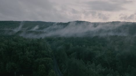 Drone-hovering-looking-at-beautiful-foggy-mountain-top-landscape