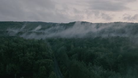 Drone-hovering-looking-at-beautiful-foggy-mountain-top-landscape-2