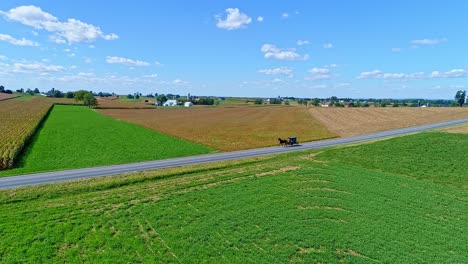 Eine-Luftaufnahme-Von-Bauernhöfen,-Silos-Und-Ackerland,-Die-Bald-Mit-Einem-Amish-Pferd-Und-Einem-Buggy-Durchfahren-Werden-2