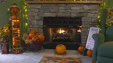 A-View-of-a-Fireplace-With-a-Fire-Going,-all-Decorated-for-Autumn-With-Pumpkins,-Scarecrows-and-Fall-Leaves
