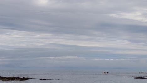 Kayakers-Slowly-Paddling-Past-Sea-Rocks-with-Dramatic-Clouds-Lee-Bay-Devon-UK-4K