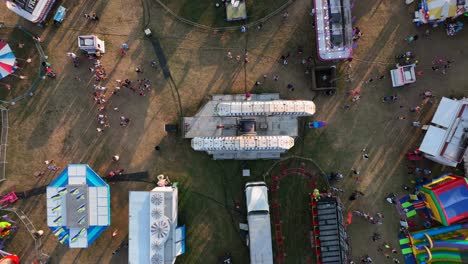 Top-down-aerial-of-people-at-outdoor-carnival-enjoy-fair-rides