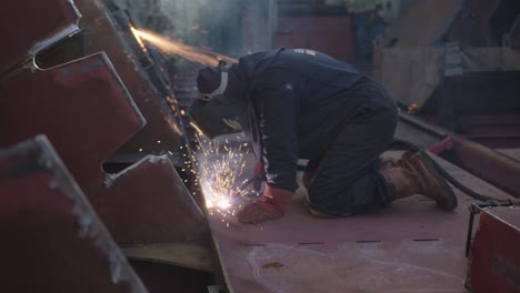 Man-in-protective-suit-and-mask-is-bussy-welding-at-a-shipyard