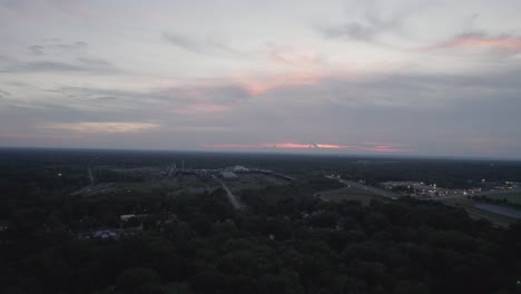 Aerial-drone-forward-moving-shot-of-an-old-lumber-mill-during-sunset-on-a-cloudy-evening