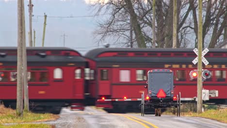 An-Amish-Horse-and-Buggy-Approaching-a-Railroad-Crossing-as-a-Antique-Steam-Passenger-Train-Passes-on-a-Winter-Day