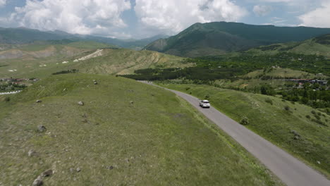 Car-Driving-Through-Empty-Road-With-Panoramic-View-Of-Mountain-Range-In-Summer-At-Daytime-In-Georgia
