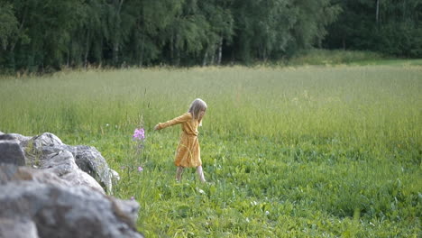 Young-girl-dreaming-of-future-career-as-she-dances-on-summer-field,-slow-motion