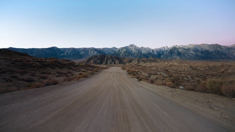 Gravel-road-leading-to-rugged-mountains,-Alabama-Hills,-Lone-Pine